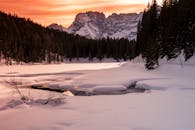 冬日里，冰冻的湖泊宁静如画，山峰上染着日落的色调