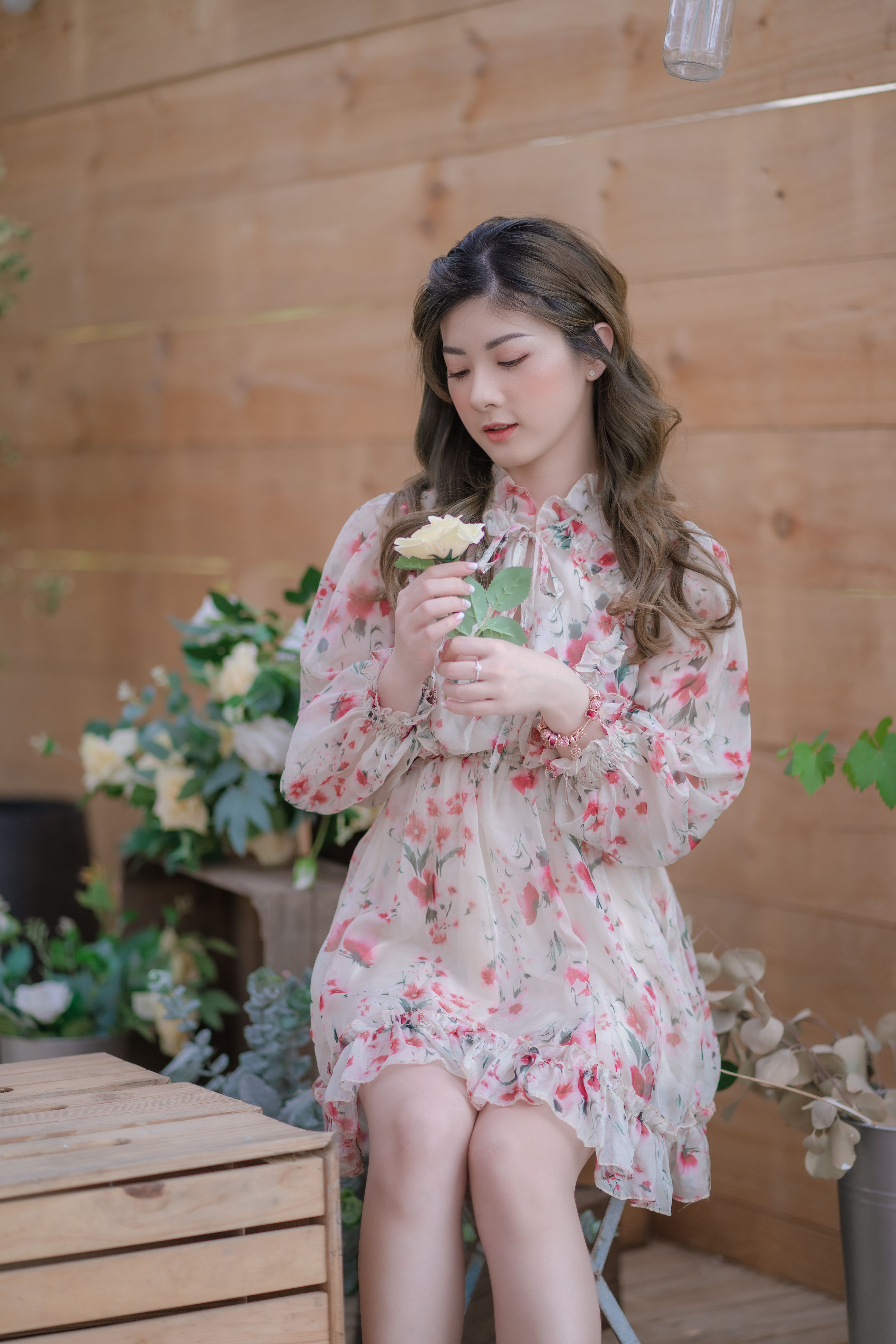 A Beautiful Woman in Floral Dress Sitting on Gray Rock · Free Stock Photo