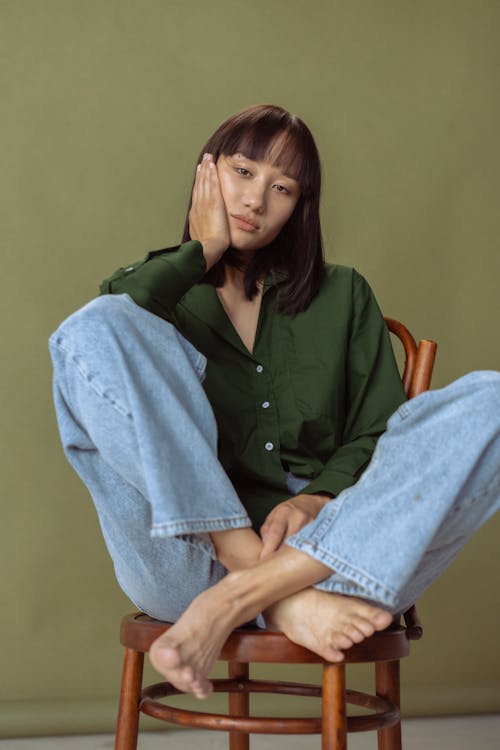 Woman in a Green Shirt Posing with Her Hand on Her Cheek