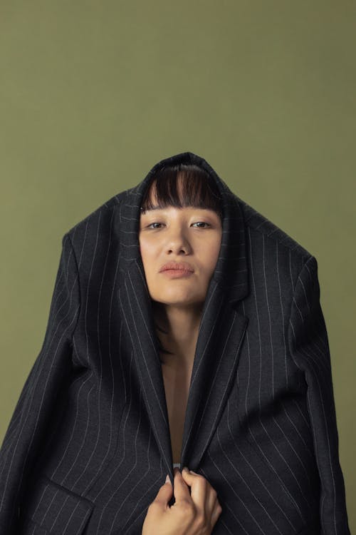 Photo of a Woman Wrapping Her Head with a Black Blazer