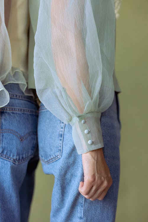 A Person in Green Chiffon Blouse and Blue Denim Jeans