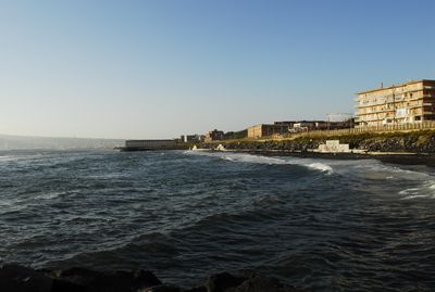 Coastal cityscape with ocean and modern buildings representing harsh-environment projects