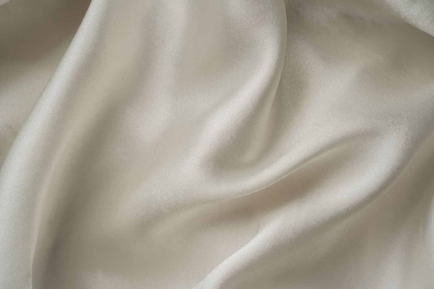 White, softly draped silk-like cloth illustrating fluid movement; not a verified modal-silk sample