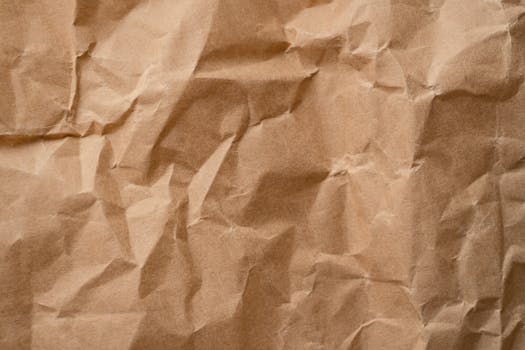 Close-up textured detail of a crumpled beige paper surface, ideal for backgrounds.