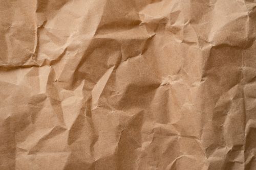 Free Close-up textured detail of a crumpled beige paper surface, ideal for backgrounds. Stock Photo