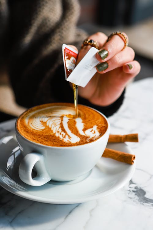 Free Person Pouring Syrup on a Coffee Drink Stock Photo