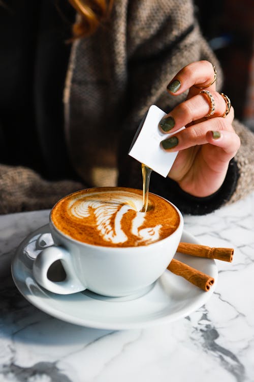 Free Person Putting Syrup in Coffee Stock Photo