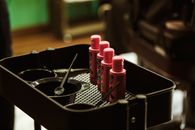 Pink and Black Plastic Bottles on Black Wooden Table