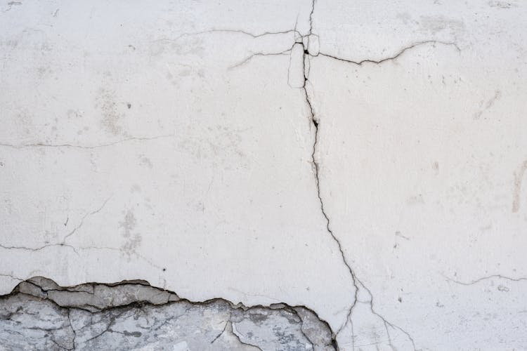 Close-Up Photo Of A White Wall With Cracks