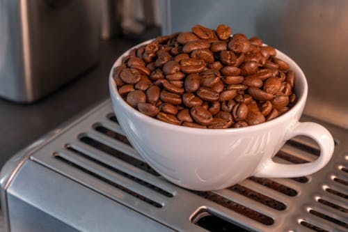 Free Close-Up Photo of Roasted Coffee Beans in a White Cup Stock Photo
