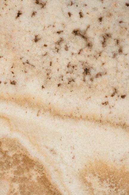 Detailed texture of beige and brown marble stone, perfect for background use.