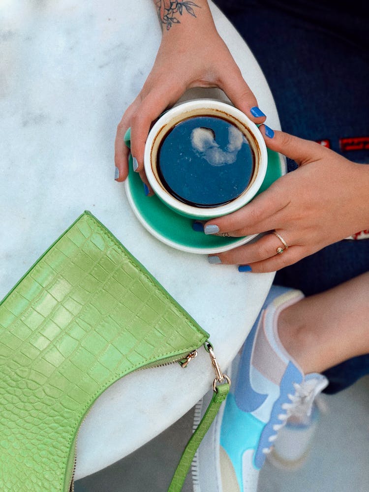 A Person Holding A Cup Of Coffee