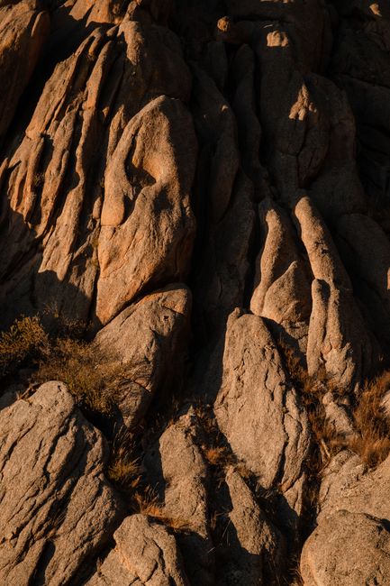 Rugged rock formations with sunlit textures and natural erosion patterns.