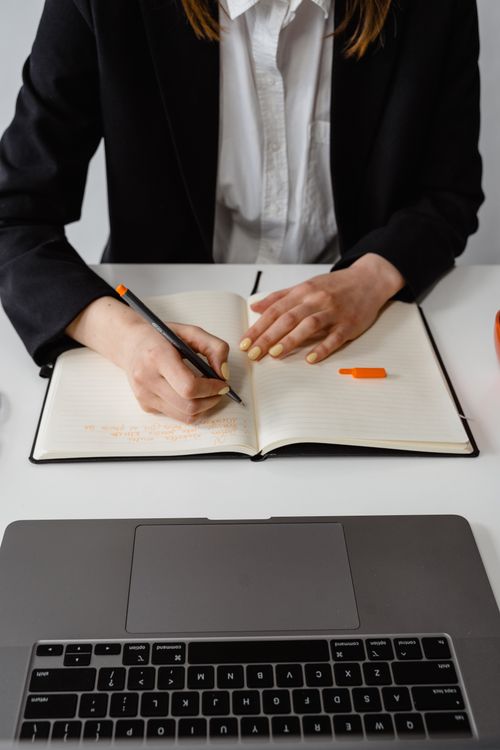 Person Writing Notes on White Ruled Paper · Free Stock Photo