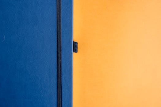 A minimalist design featuring a blue notebook against a bright yellow backdrop.