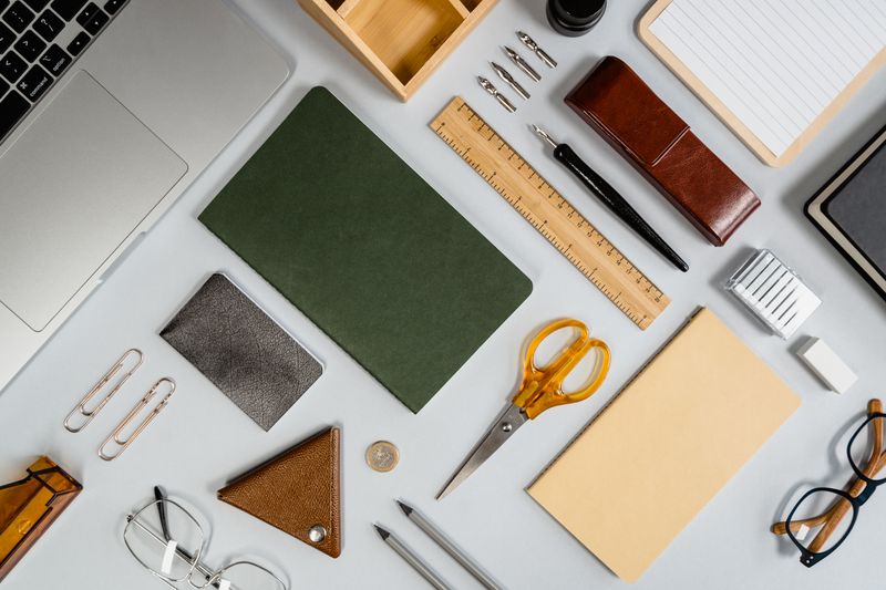Flat lay of office supplies including notebooks and pens
