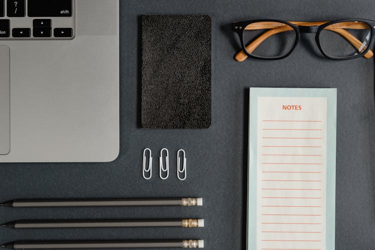 Stationery And Eyeglasses On Black Background