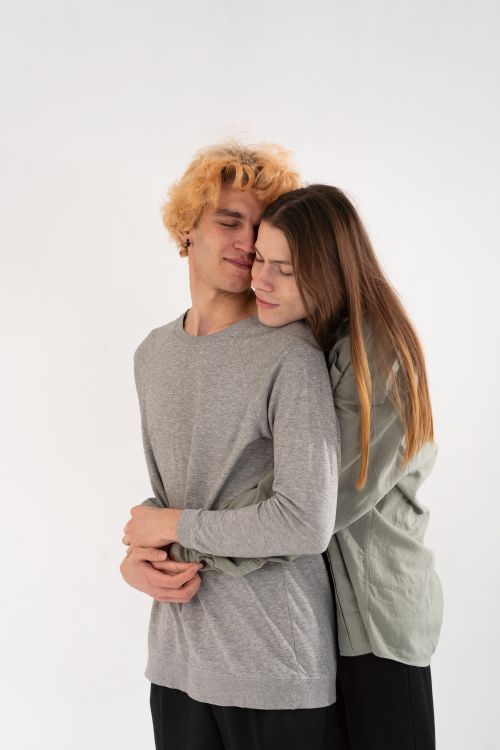 Free A young couple in love sharing a heartfelt embrace against a white background. Stock Photo
