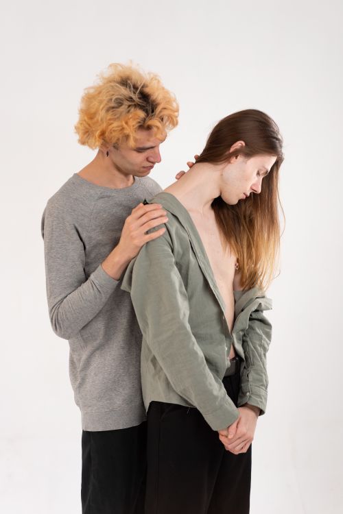 Free A heartwarming image capturing two friends in a tender embrace on a white studio background. Stock Photo