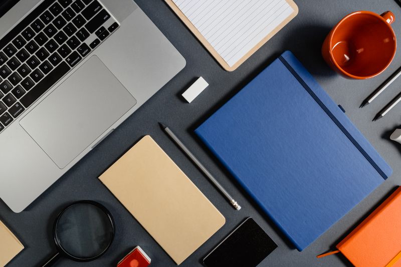 Tidy workspace with laptop, notebooks and office supplies