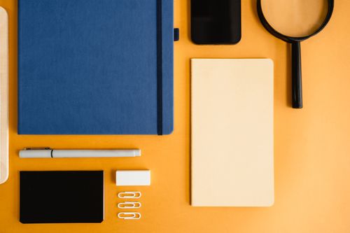 Free Artistic flat lay of diverse office stationery on a vibrant yellow background. Stock Photo