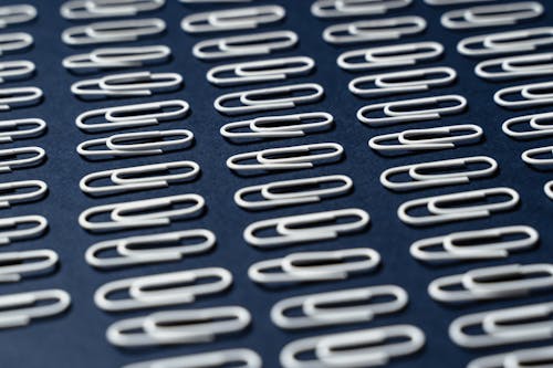A Close-Up Shot of Paper Clips on a Blue Surface