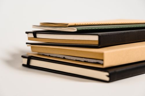 Free Close-up of various notebooks stacked against a white background. Stock Photo