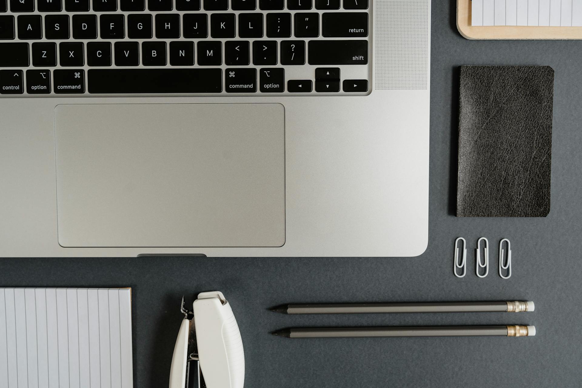 Flat lay of a clean, organized workspace featuring a laptop and office accessories for a minimalist look.