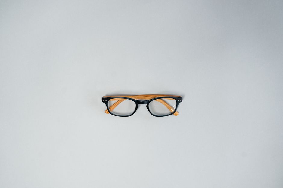 Stylish eyeglasses centered on a plain gray background, perfect for eyewear ads.