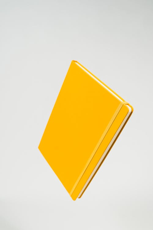 Free Yellow Notebook on Gray Background Stock Photo