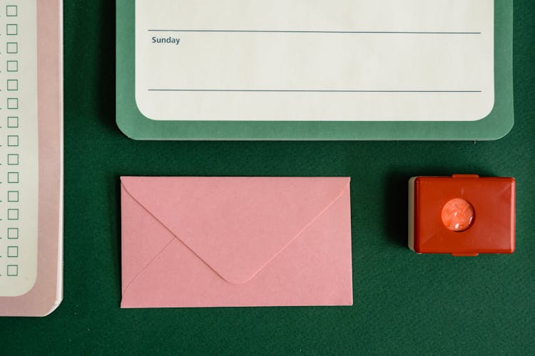 Pink Envelope Beside A Notepad