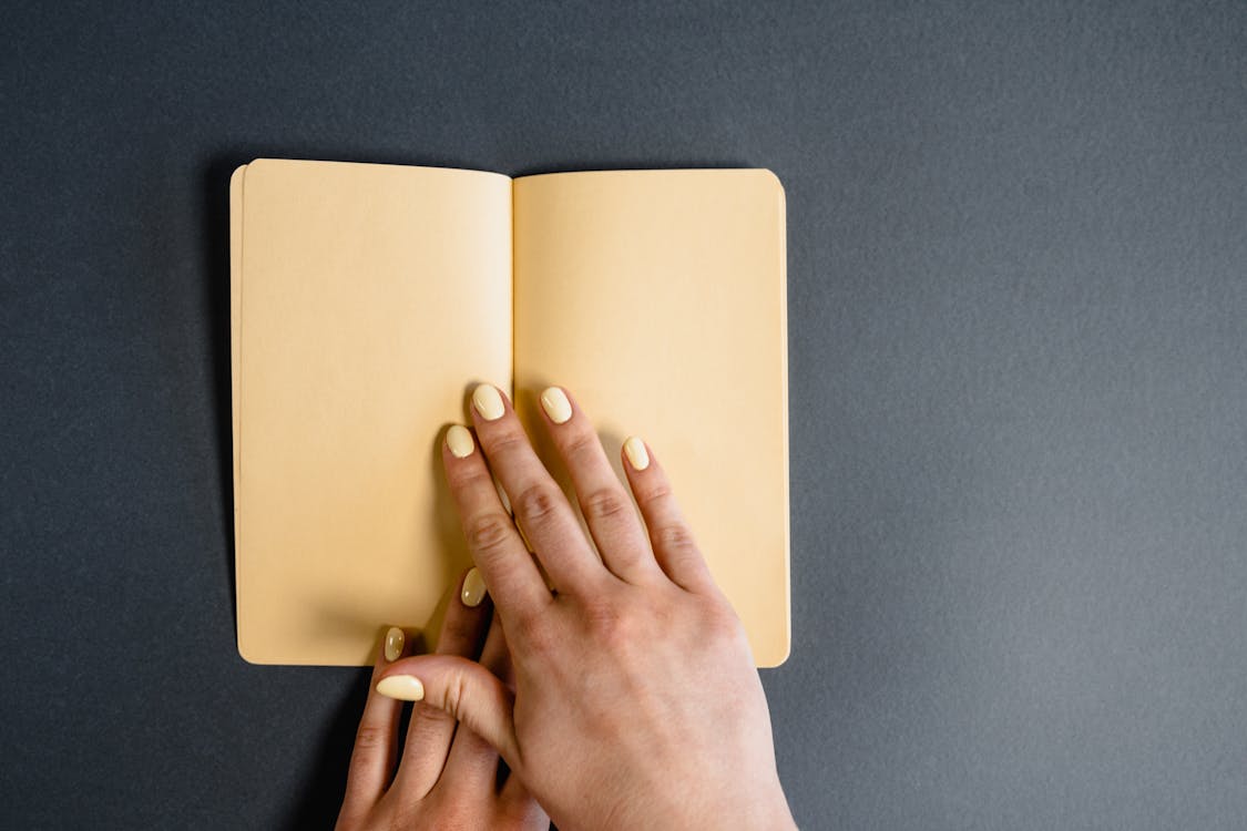 Person Opening a Blank Notebook · Free Stock Photo