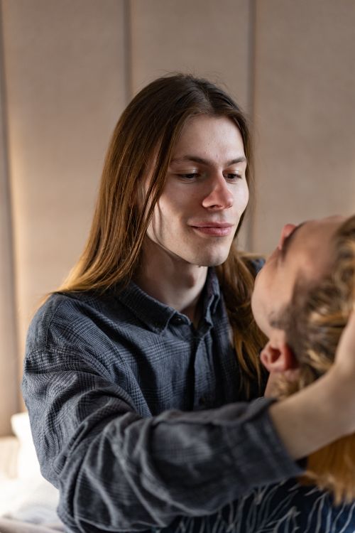 Free A tender and affectionate moment captured between two men indoors, expressing love and connection. Stock Photo