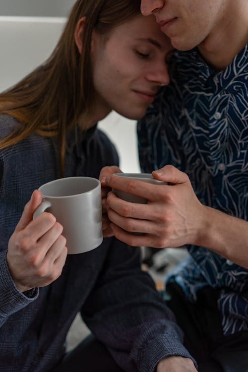 Free A Couple Leaning on Each Other while Holding Mugs Stock Photo