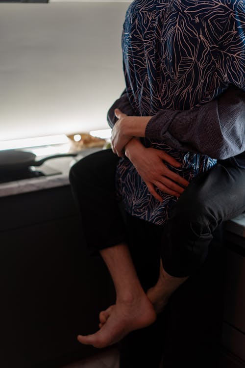 Free Couple Hugging while in the Kitchen Stock Photo