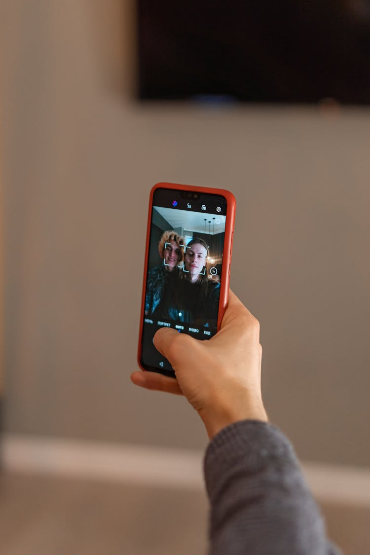 Person Holding Iphone 6 With Red Case