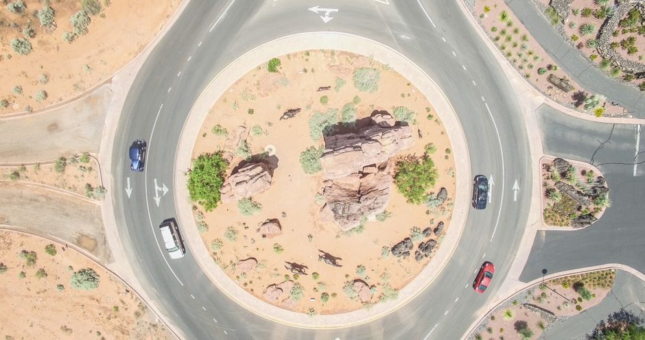 Unforgettable Bryce Canyon National Park 30-Minute Helicopter Tour Review 2026 - Aerial shot of a roundabout in a desert landscape with cars and rocky terrain.