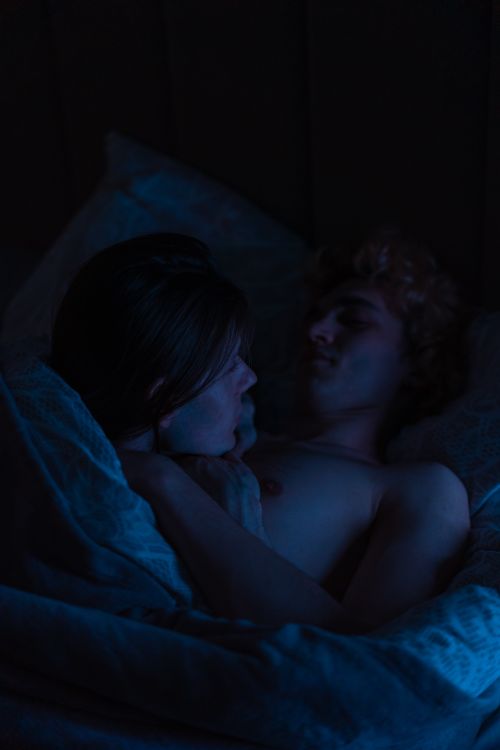 Free A close-up of a loving couple sharing an intimate moment while lying in bed. Stock Photo