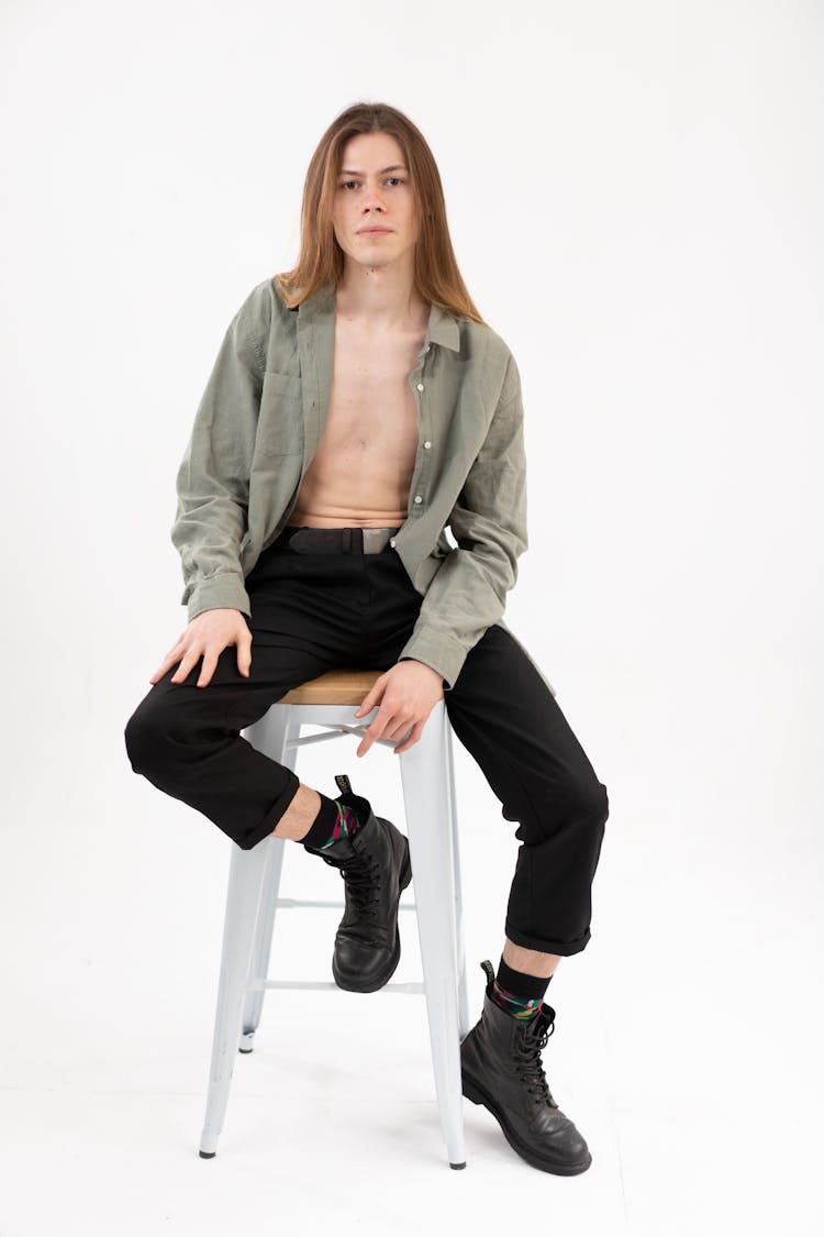 Man With Long Hair Sitting On A Stool