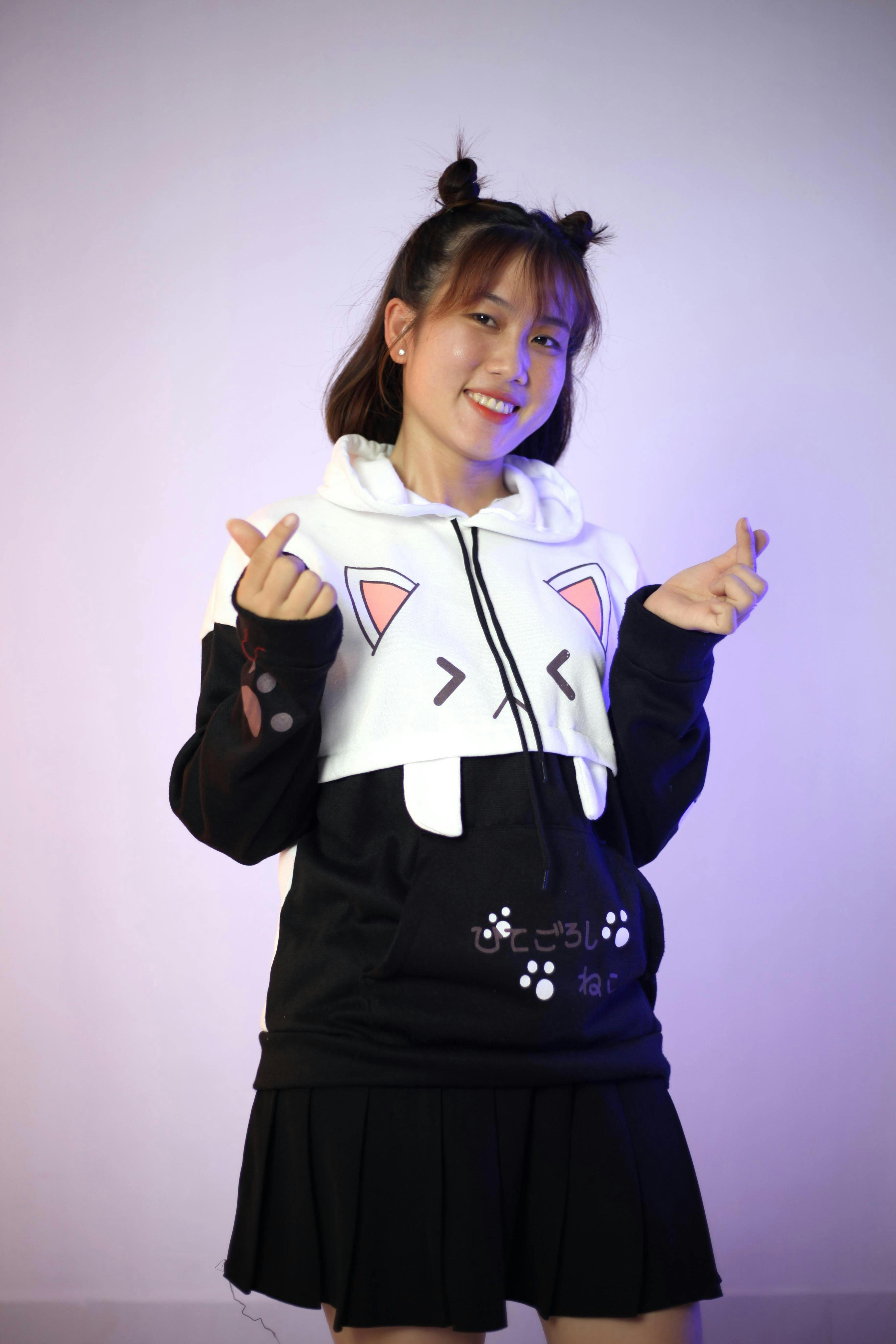 cheerful asian woman in casual trendy hoodie and skirt