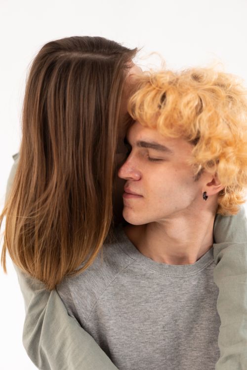 Free A young couple sharing a warm embrace, exuding love and closeness in a tender moment. Stock Photo