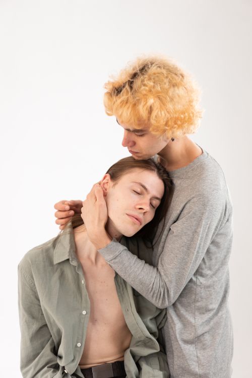 Free Two people share a tender embrace, conveying love and comfort in an intimate indoor setting. Stock Photo