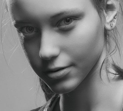 Grayscale Photo of a Beautiful Woman with Earrings Looking at the Camera
