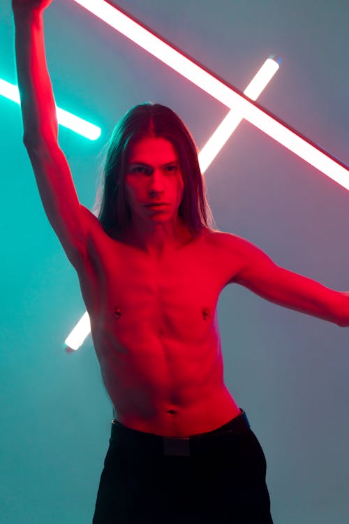 Topless Man Holding a Neon Light