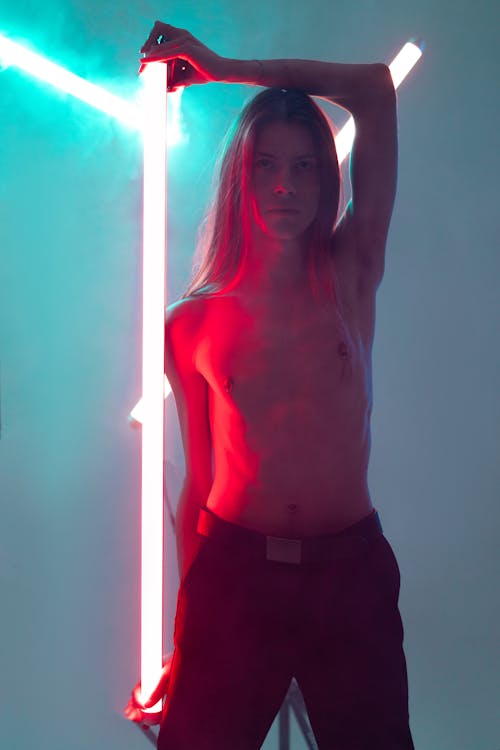 Shirtless Person Holding a Neon Light