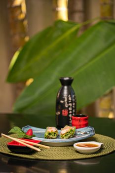 Elegant presentation of fresh spring rolls with dipping sauce on a decorative plate, perfect for Asian cuisine lovers.