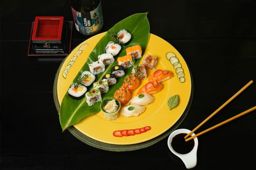 Free A beautifully arranged sushi platter with nigiri, uramaki, and elegant garnishes on a vibrant plate. Stock Photo