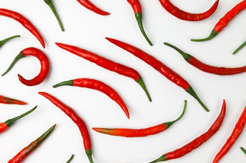 Free Overhead shot of fresh red chili peppers on white backdrop, showcasing vibrant colors. Stock Photo