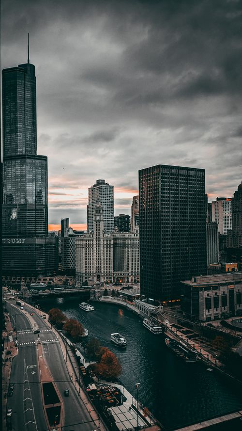 Free Moody cityscape of Chicago with river, skyscrapers, and overcast sky. Stock Photo