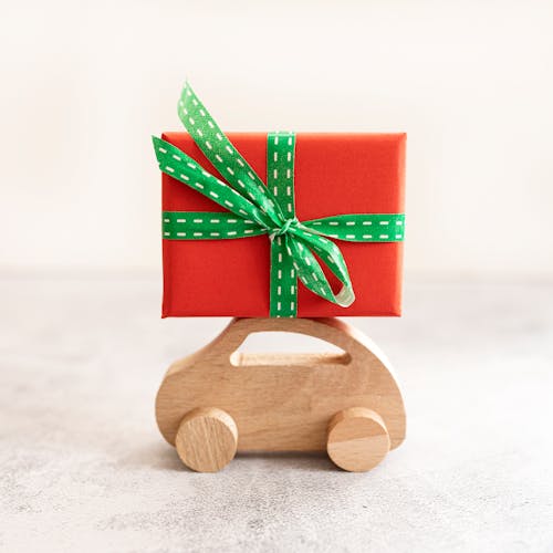 Free Gift Box on Top of a Wooden Toy Car Stock Photo
